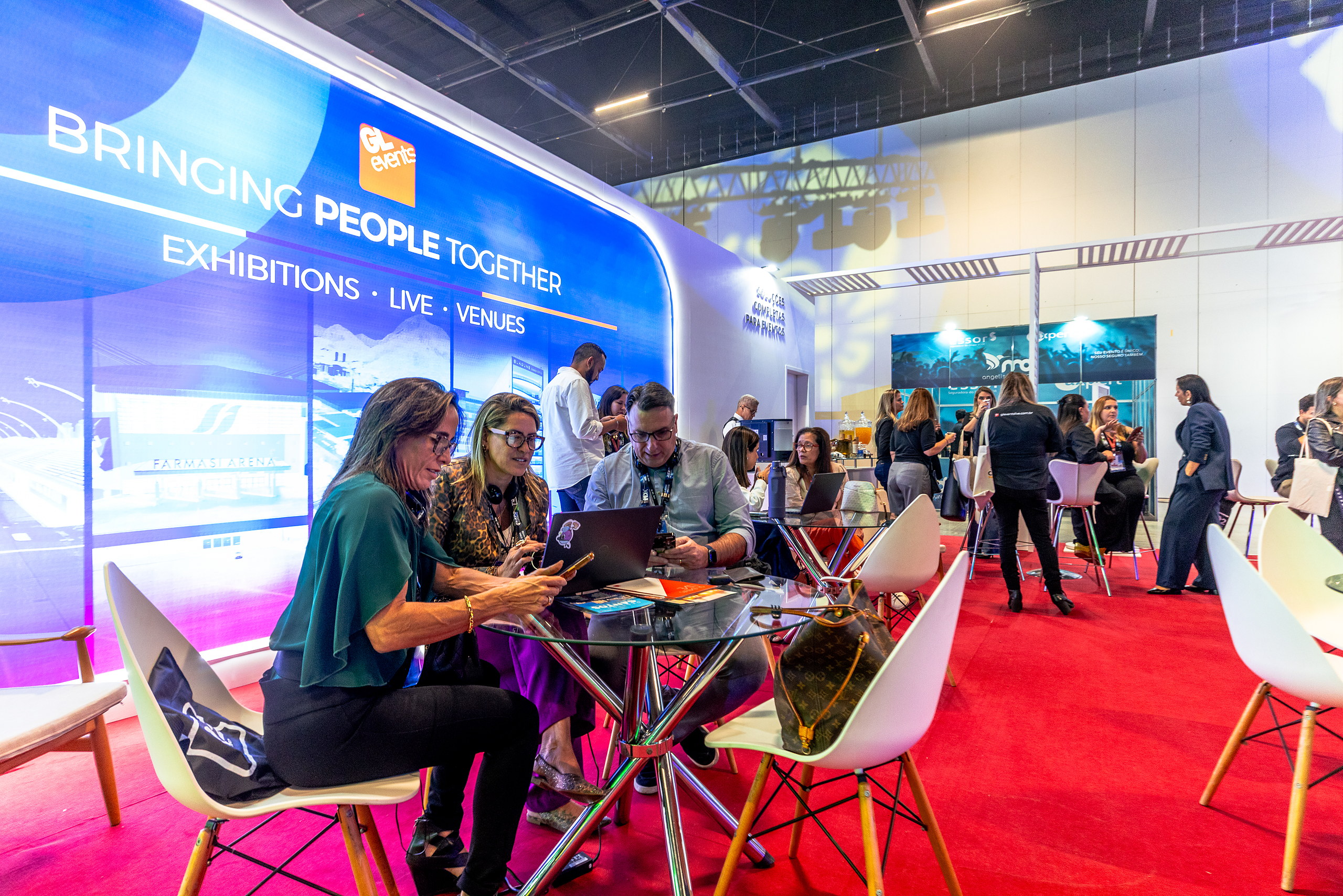 Participantes reunidos em mesa de estande na 5ª Expo ABRAPE